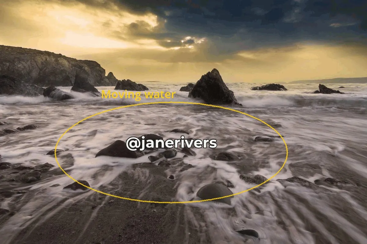 A GIF frame of waves washing over rocks with a watermark placed in the middle of the moving water