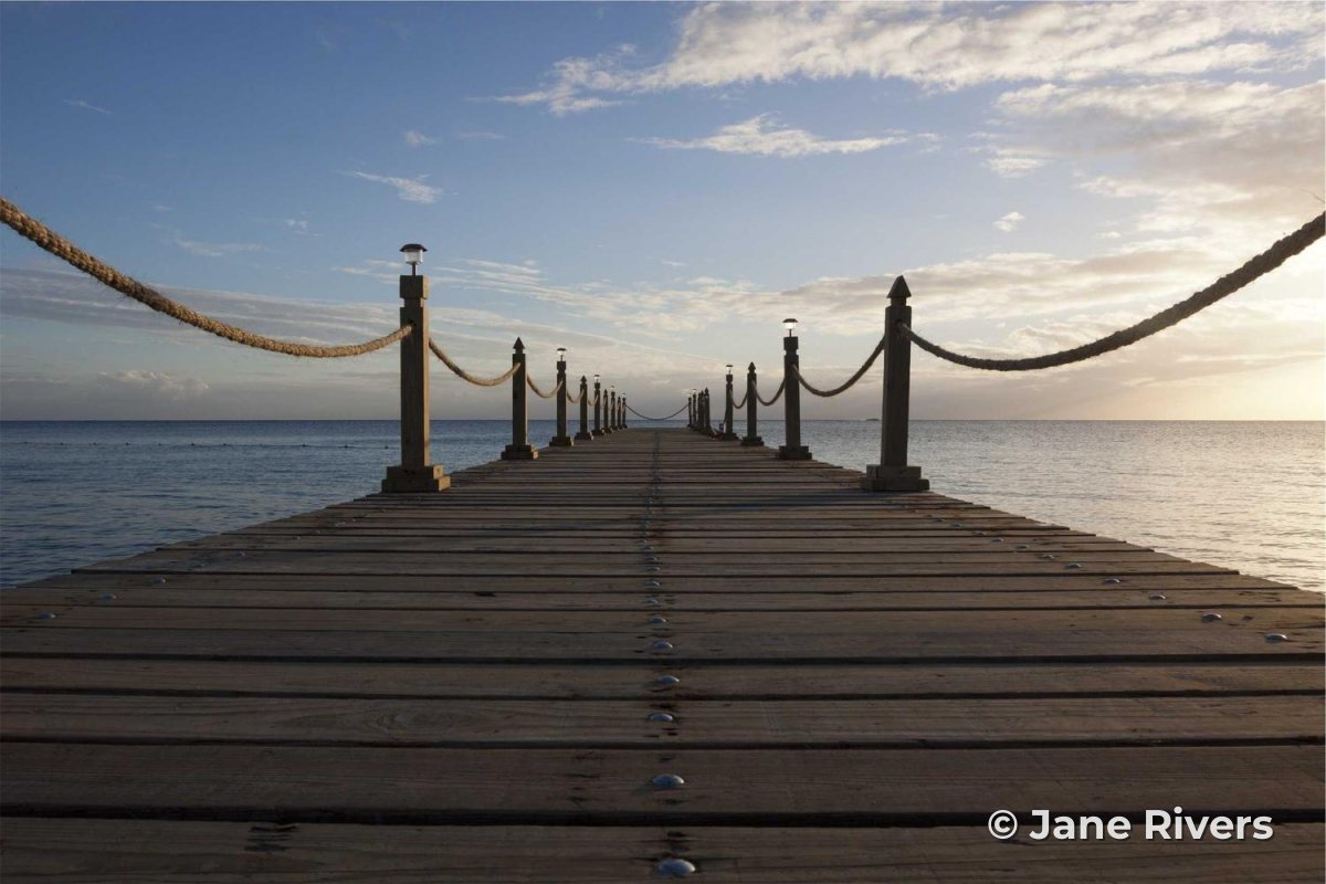 A landscape photo of a jetty with a small mark in the lower right corner