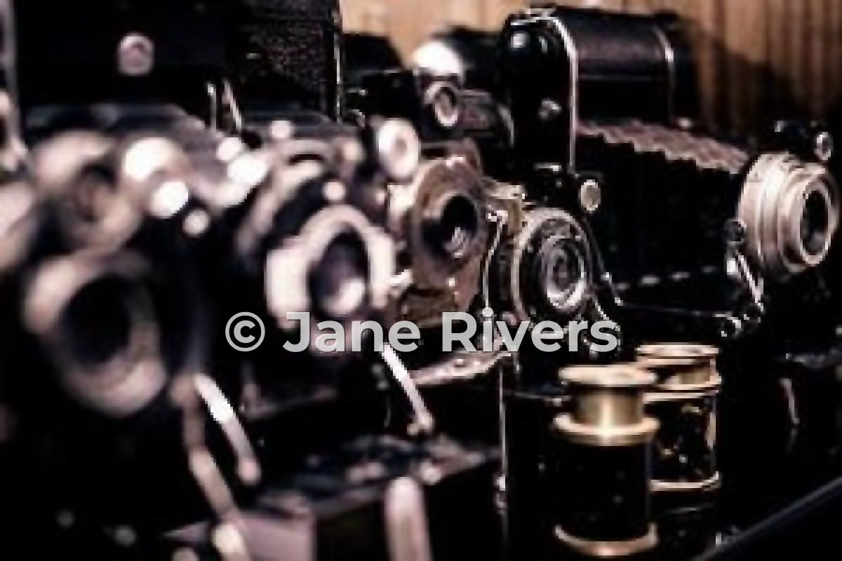 A shelf of vintage cameras with a © Jane Rivers watermark across the photo