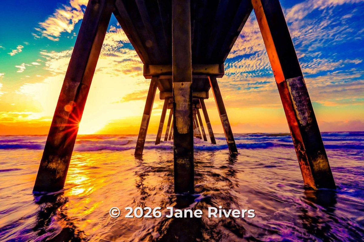 A sunset under a pier with the notice © 2026 Jane Rivers along the bottom of the photo
