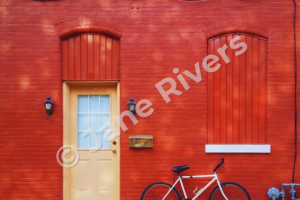 A red brick wall with a door and a bicycle, and a watermark rising from bottom-left to top-right