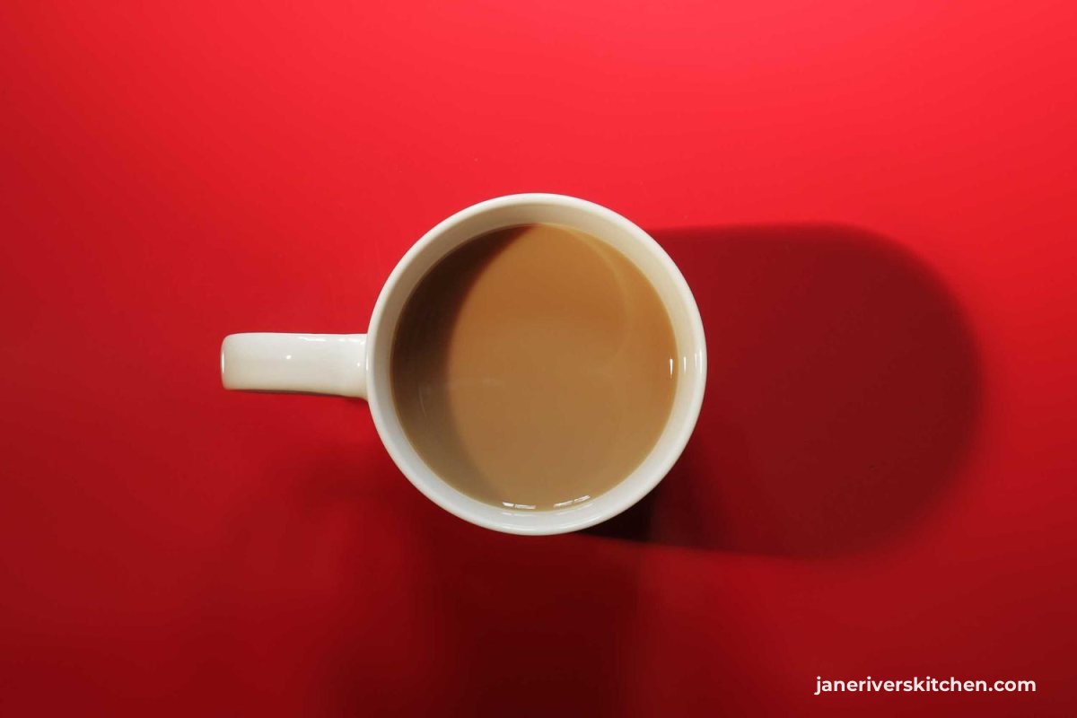 An overhead photo of a coffee cup on a red surface with the watermark in the far corner