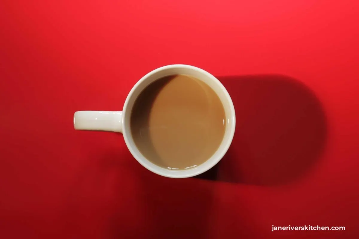 An overhead photo of a coffee cup on a red surface with the watermark in the far corner