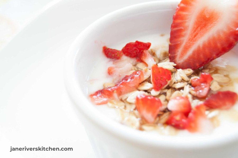A bright yogurt bowl with a small dark website watermark in the lower left