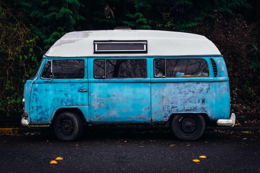A weathered blue camper van with no watermark