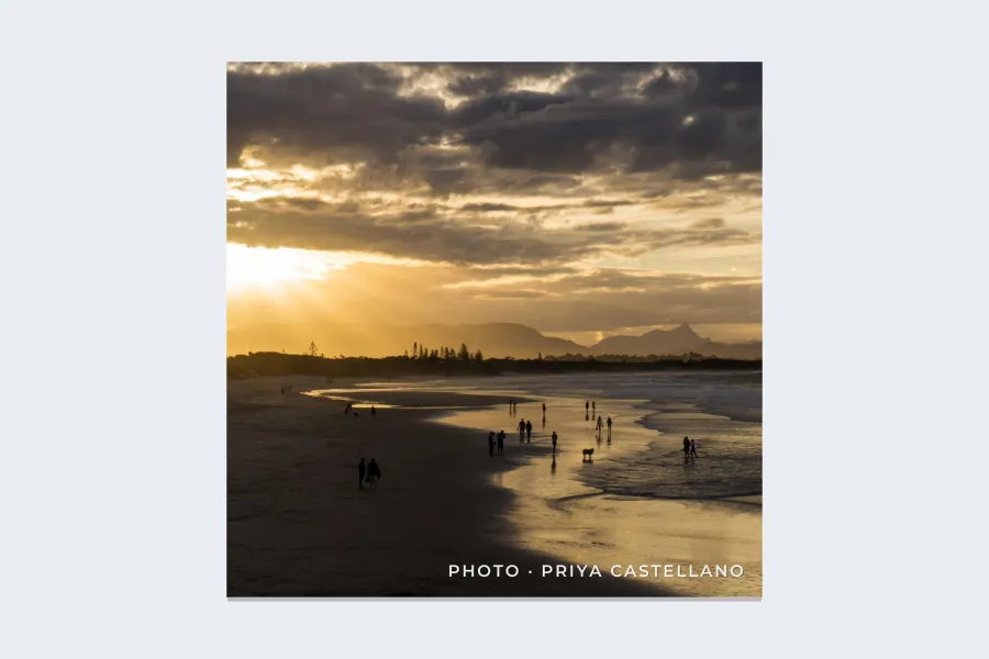 A square photo of a beach at sunset with PHOTO · PRIYA CASTELLANO in small white letters in the lower right corner
