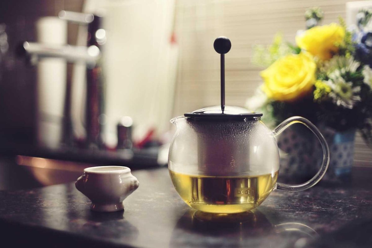 A glass teapot and cup with no watermark