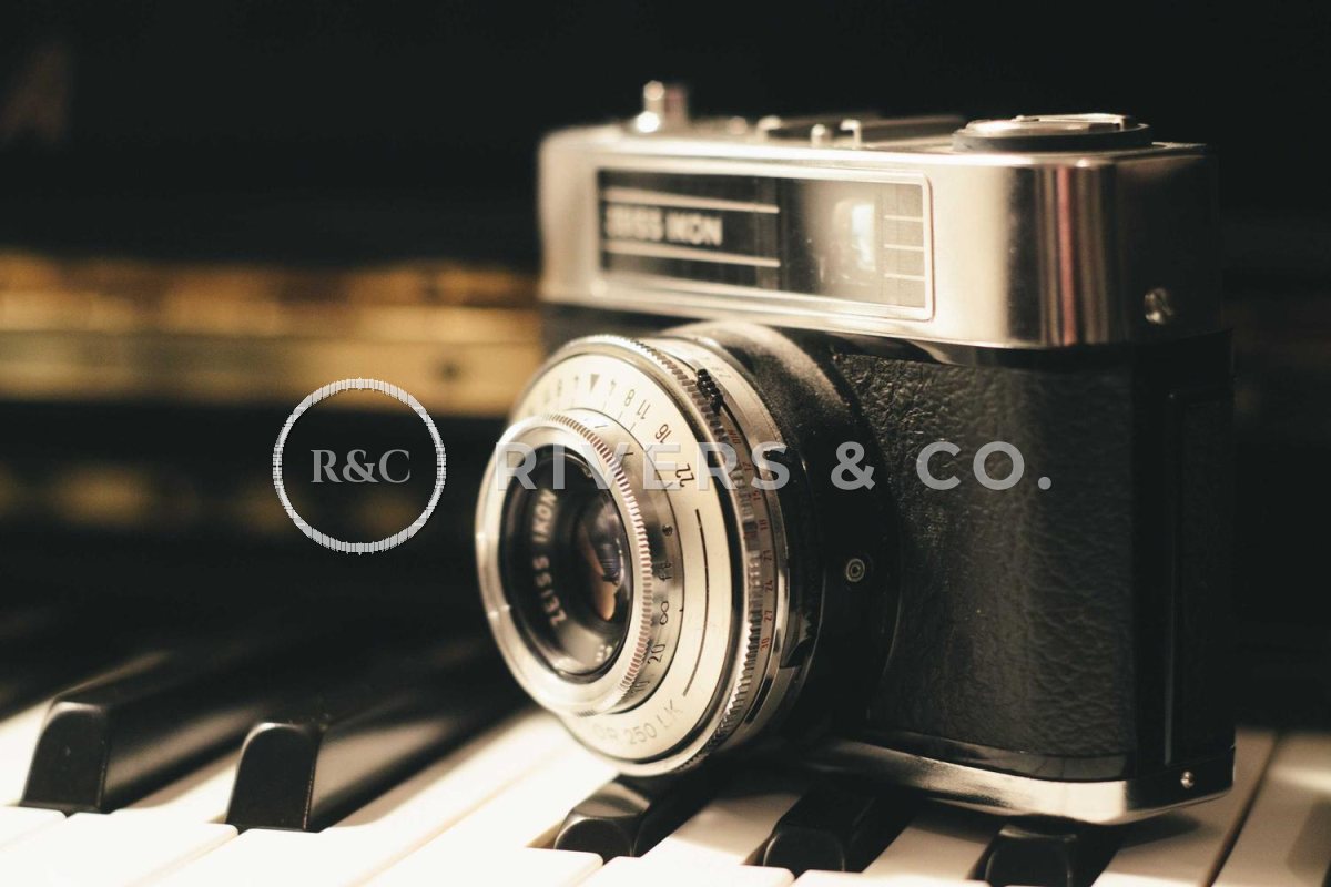 The camera with a large semi-transparent logo across the lens and body