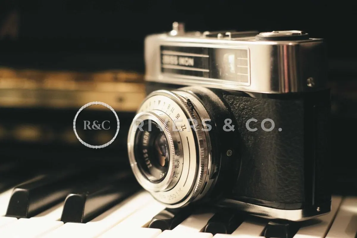 The camera with a large semi-transparent logo across the lens and body