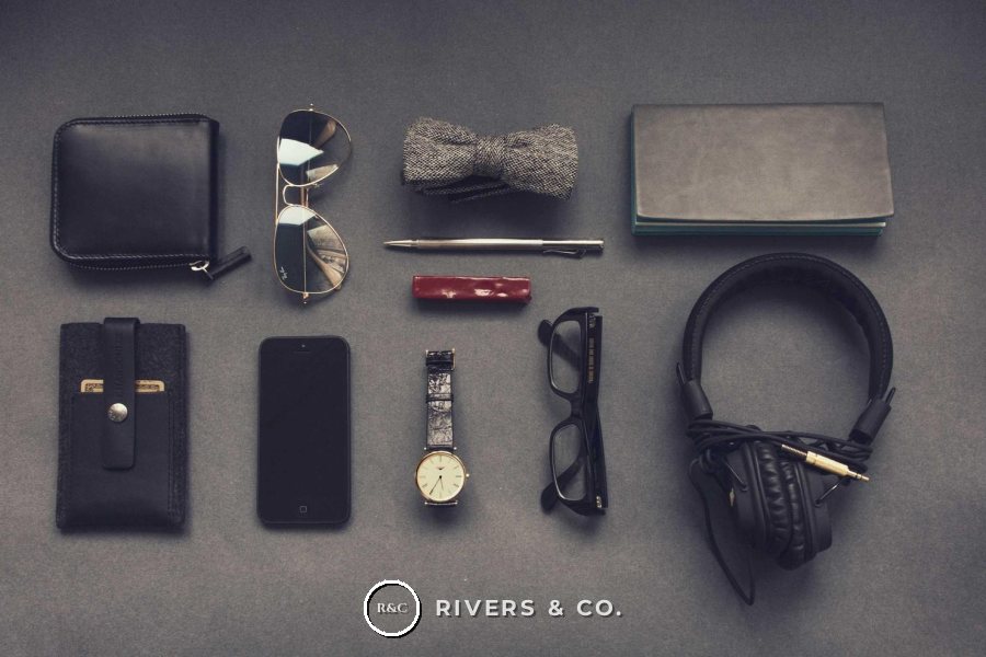 A flat lay of accessories with a small logo centered below the items