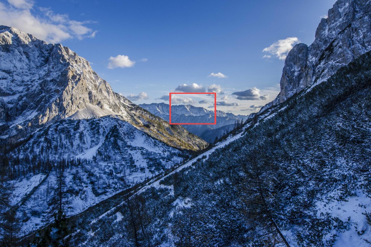 A mountain valley photo with a small red rectangle around a distant ridge