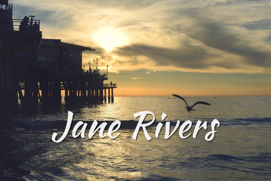 Jane Rivers in Kaushan Script, a bold brush script, over a pier at sunset