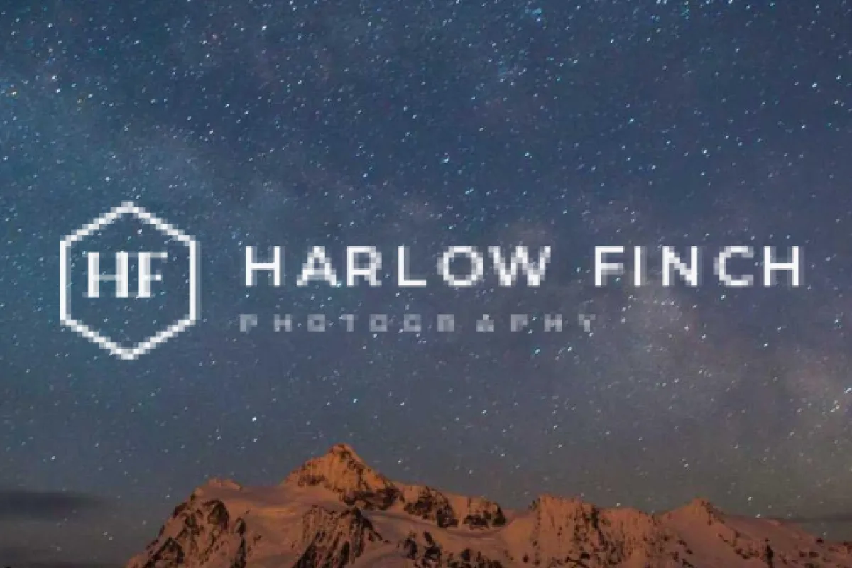 A close-up of a white logo on a starry night sky with blocky, blurred edges and unreadable small lettering