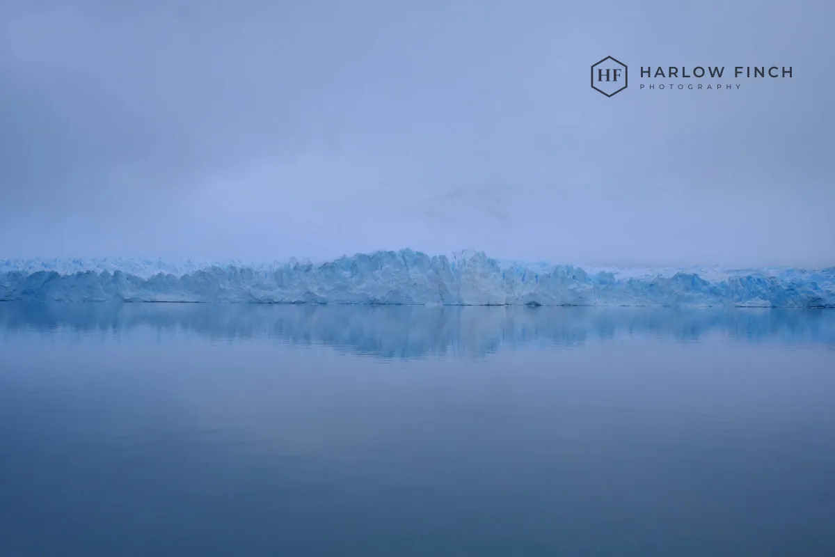 The same lake with the same dark logo placed directly on the sky, with no box around it