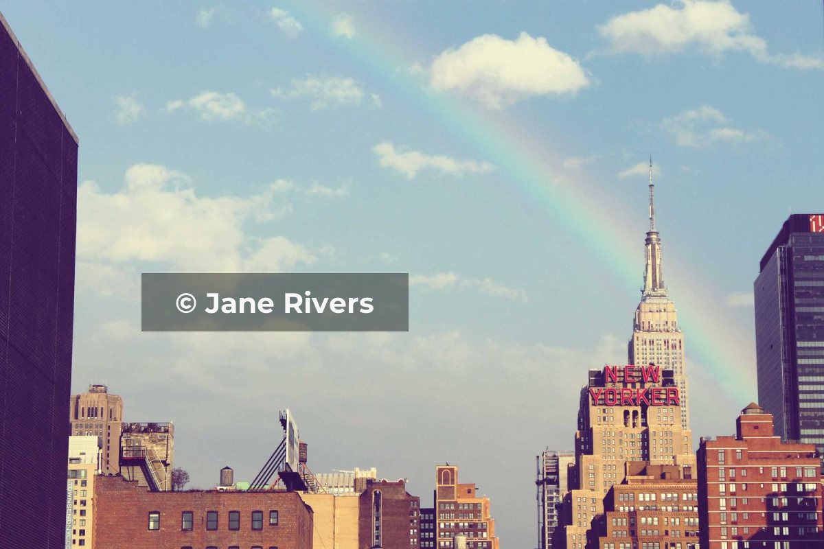 A city skyline with a rainbow and a name-only watermark