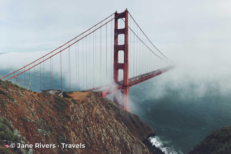 A suspension bridge in fog with the watermark in the lower left