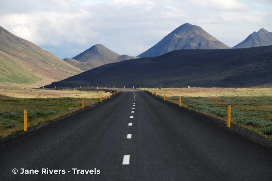 A road through mountains with the watermark in the lower left