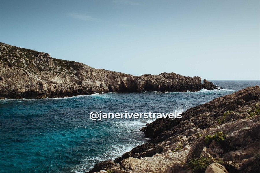 The same coastline with a social media handle near the rocks