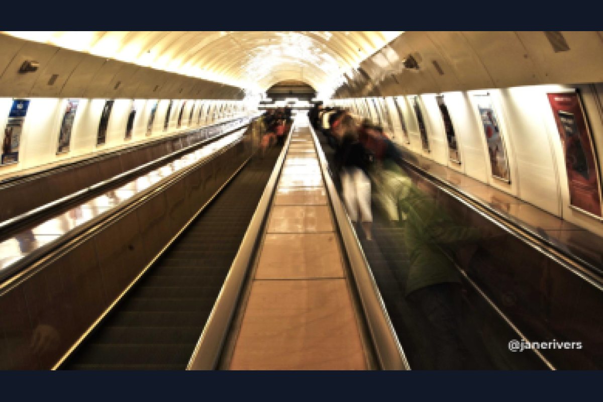 A frame of a moving walkway shrunk to phone size, with a small handle in the corner that has blurred into an unreadable smudge