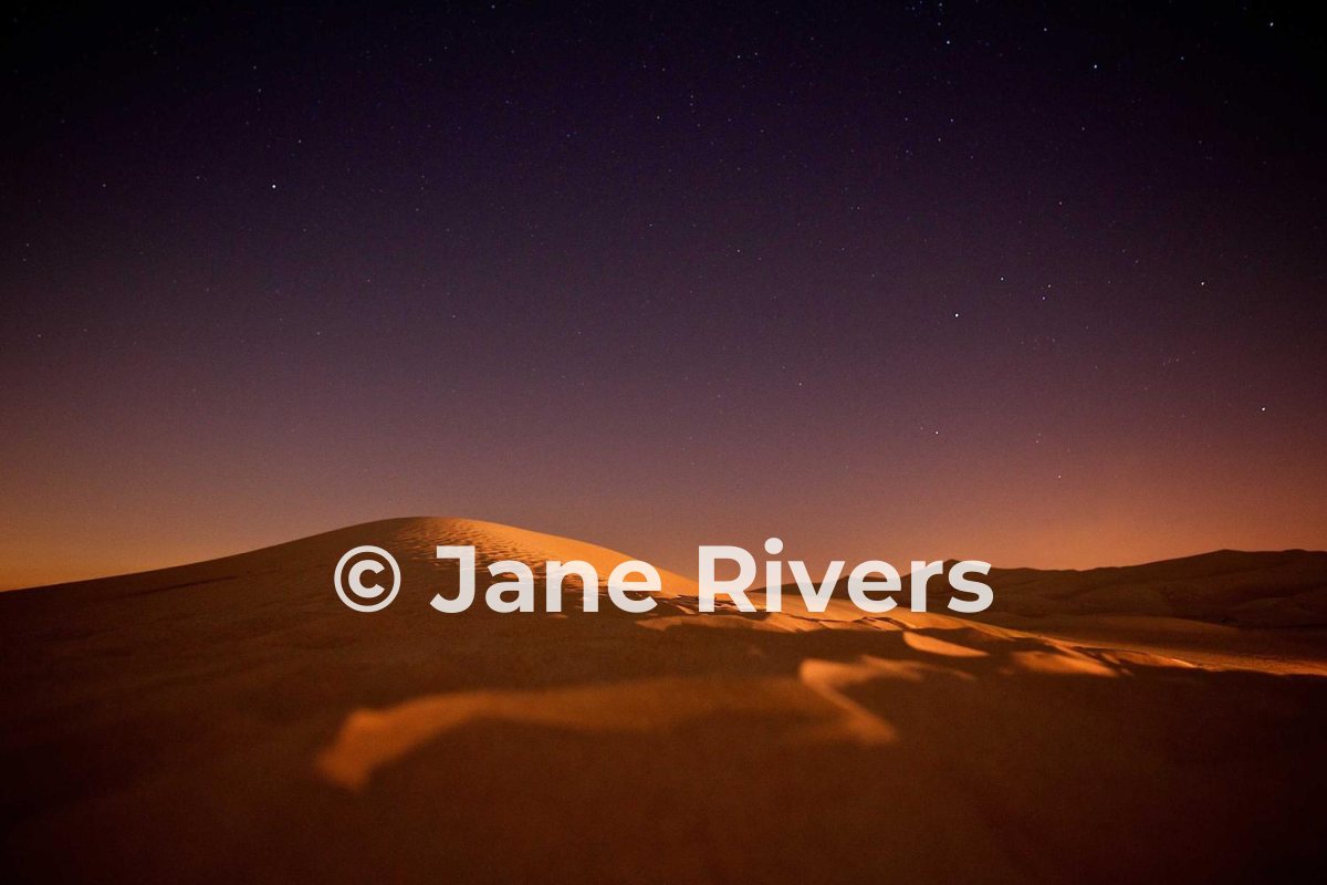 The same night desert photo with a white watermark that stands out clearly