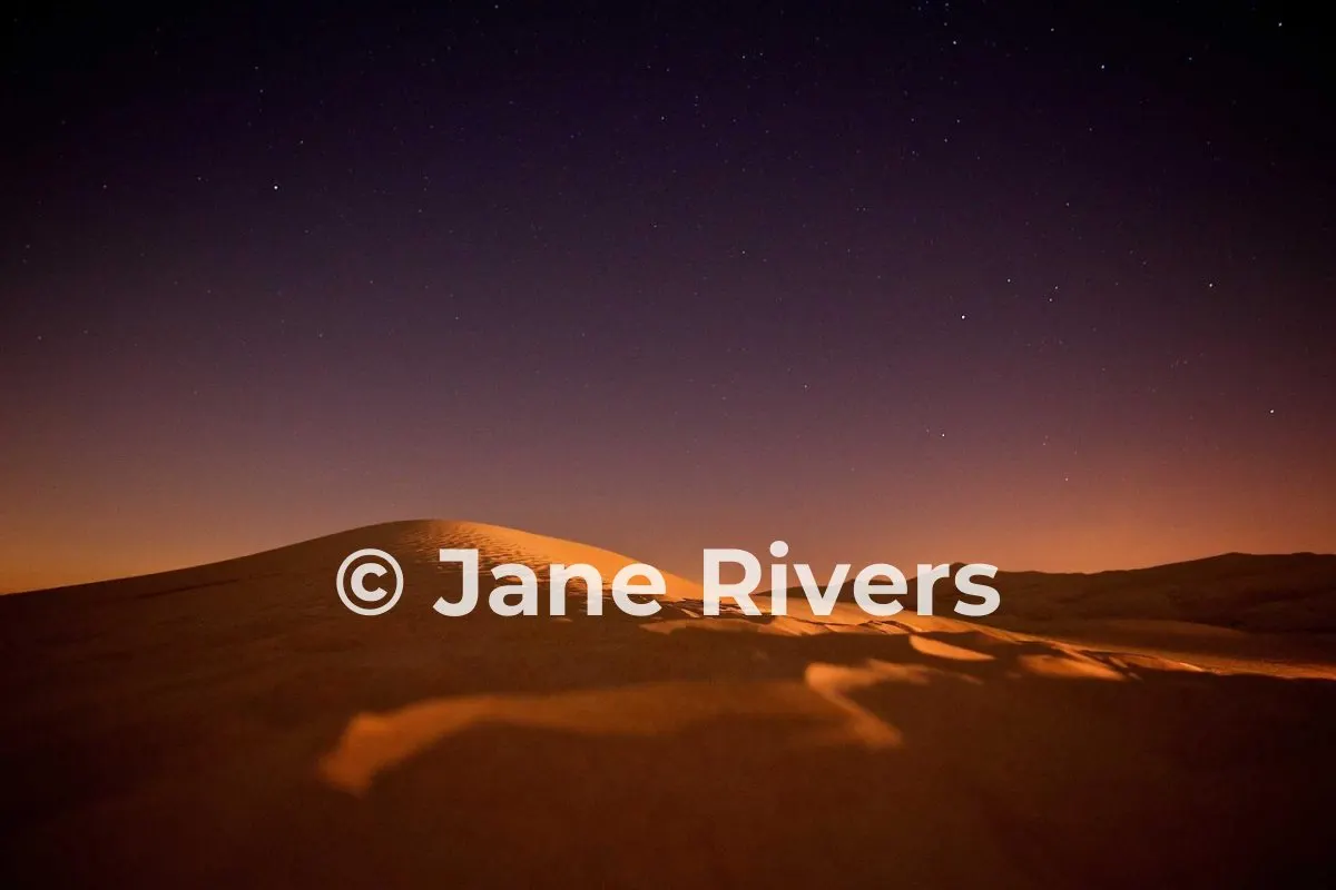 The same night desert photo with a white watermark that stands out clearly