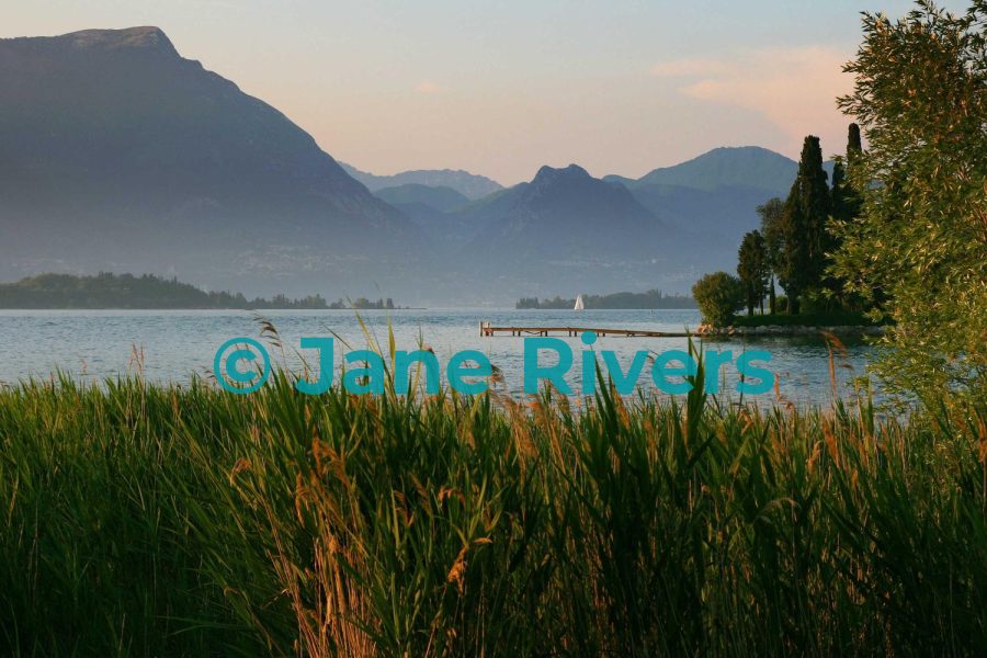 The same lake photo with a teal watermark that merges with the water