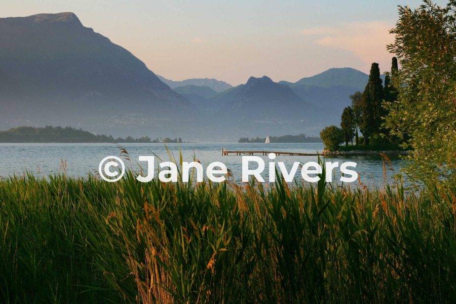 A lake and mountains photo with a white Jane Rivers watermark