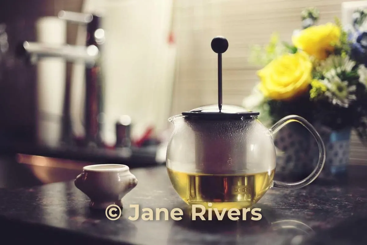 The same teapot photo with a warm cream watermark that matches the light in the photo