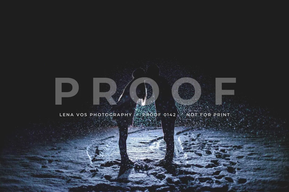 A couple silhouetted in falling snow at night with a large, faint PROOF across the middle and LENA VOS PHOTOGRAPHY, PROOF 0142, NOT FOR PRINT in small white capitals beneath it