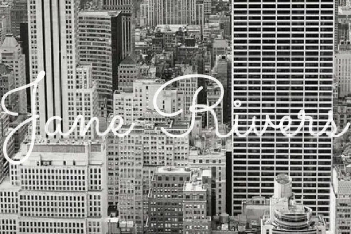 A close-up of a thin script watermark over city buildings, with most of the buildings visible between the strokes