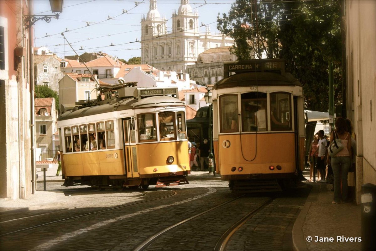 Yellow trams on a street in Lisbon with a small watermark in the bottom-right corner