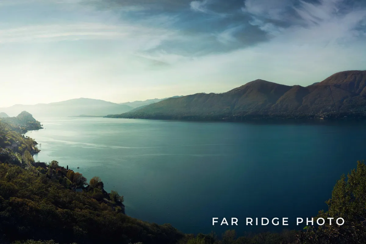 A long lake between forested mountains, with FAR RIDGE PHOTO in white spaced capitals in the lower right