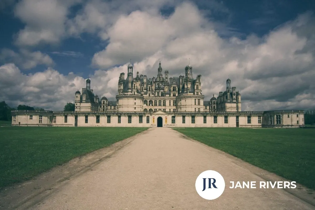 A chateau photo with a solid white circular logo and name in the corner at full opacity