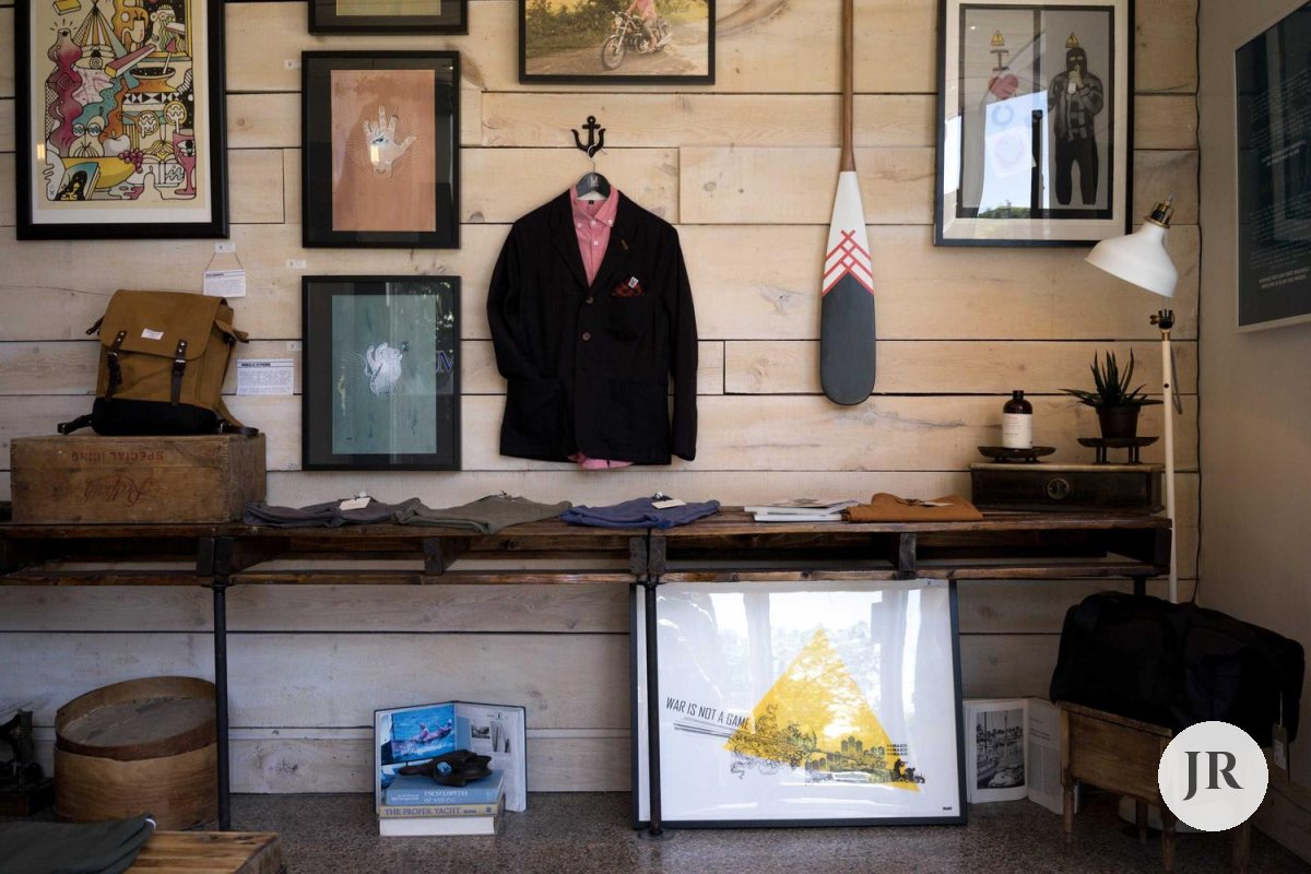 The same shop interior with a small round monogram logo in the bottom-right corner