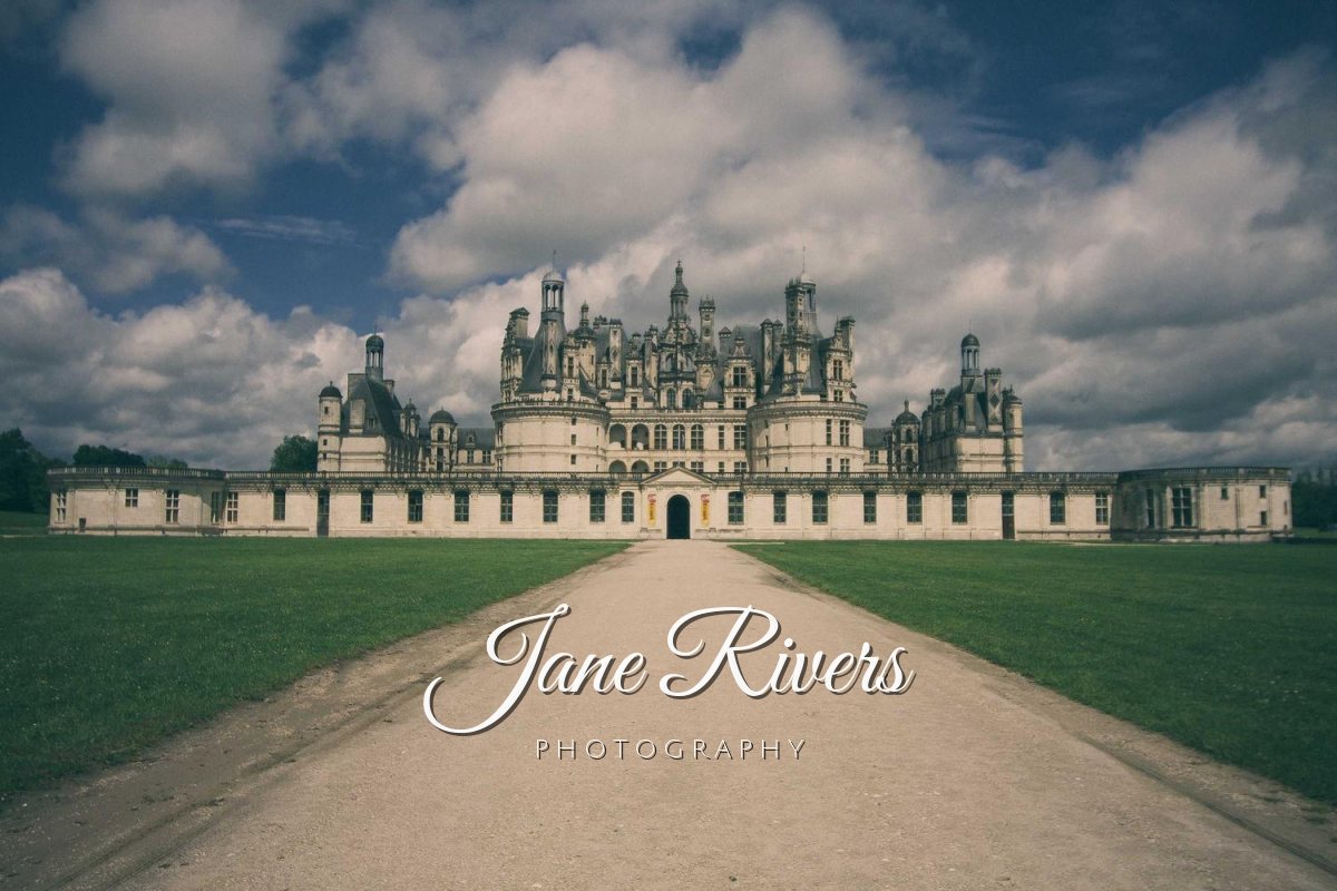 A chateau at the end of a long path with a script signature watermark reading Jane Rivers Photography